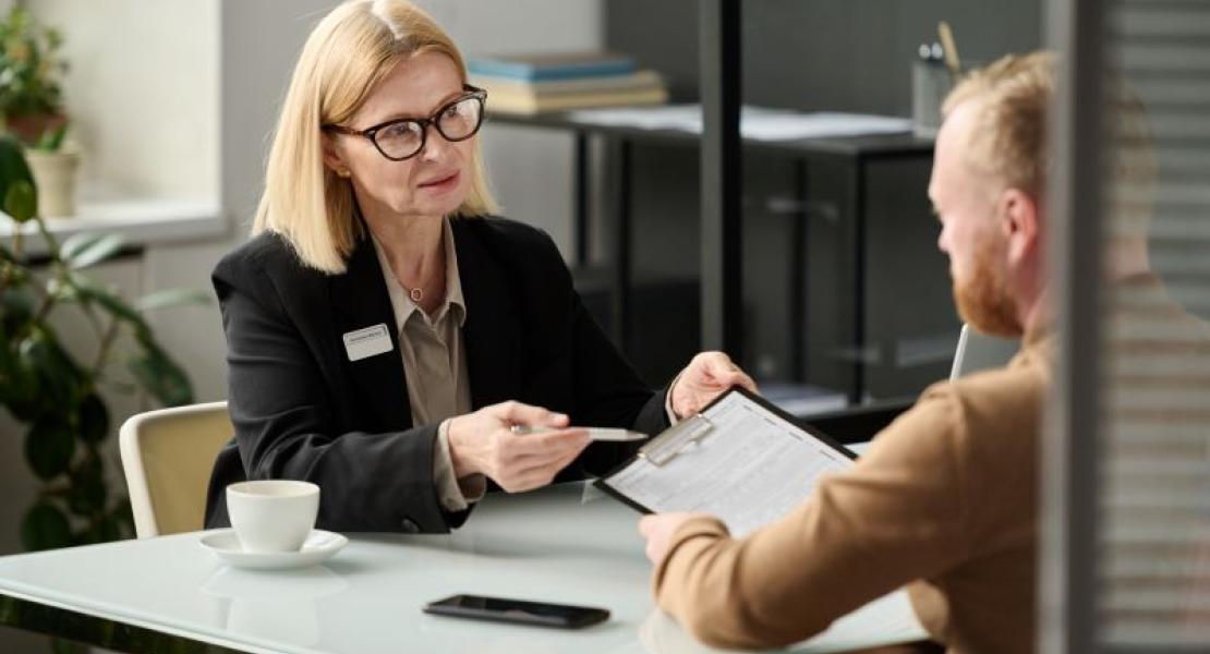 two adults talking as they look over forms