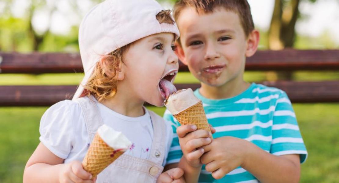 little boy sharing his ice cream with a little girl
