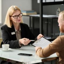 two adults talking as they look over forms