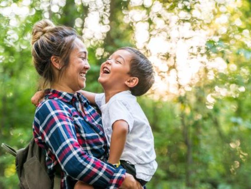 woman holding a little boy and laughing